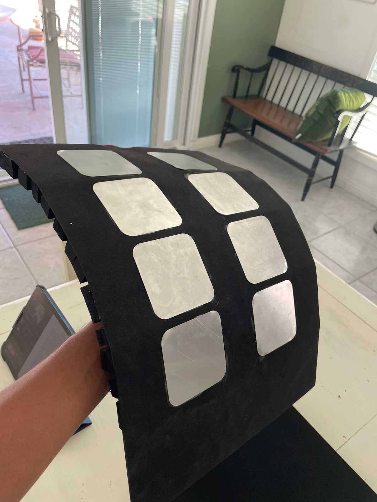 Flexible thermoelectric panel bending over a forearm, showing the conductive plates