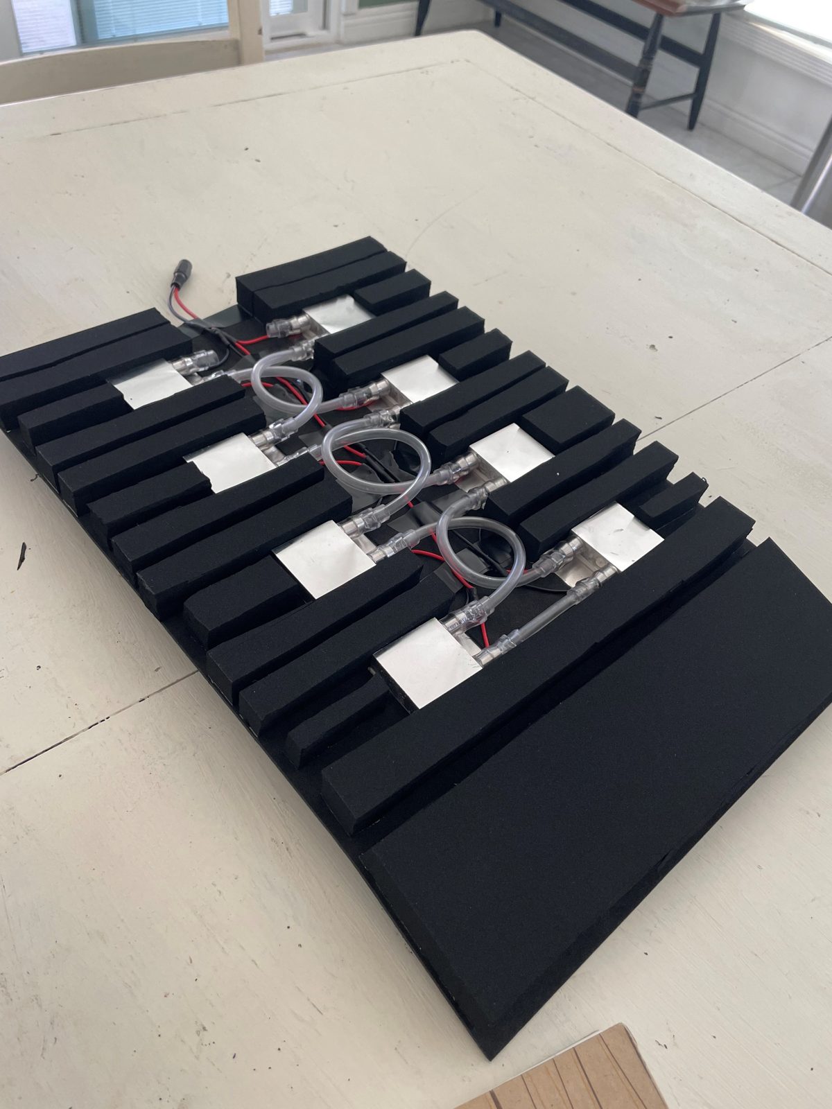 Underside of the prototype showing modules, tubing, and series wiring